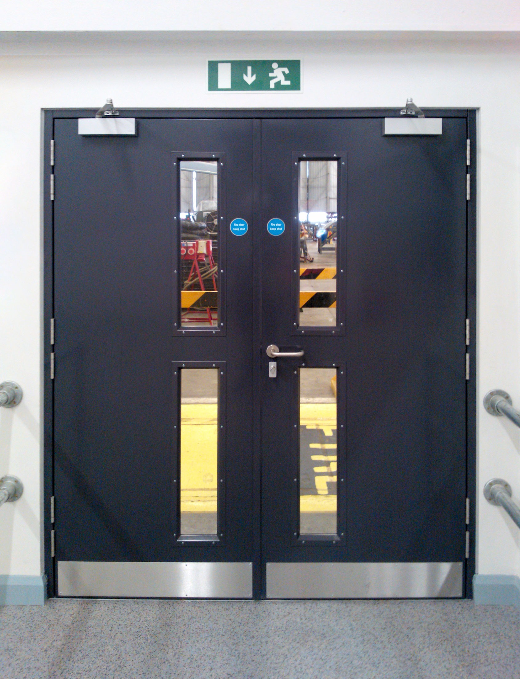 A set of fire doors with a fire exit sign above.